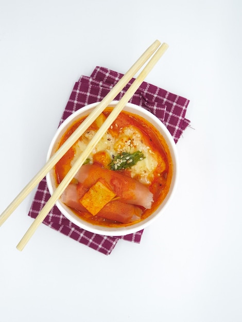 Un plato de sopa con un par de palillos encima