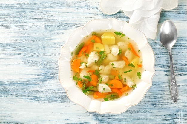 Foto plato con sopa de pollo en una mesa de madera