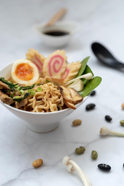 Un plato de sopa de ramen con todos los ingredientes sobre una mesa de mármol