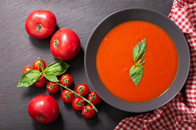 Plato de sopa de tomate con vista superior de albahaca