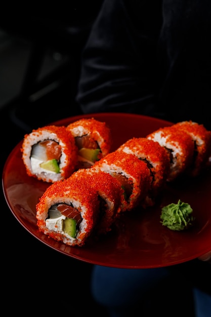 Un plato de sushi con una verdura verde encima