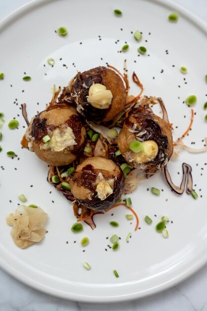 Foto un plato de takoyaki sobre una mesa de mármol.