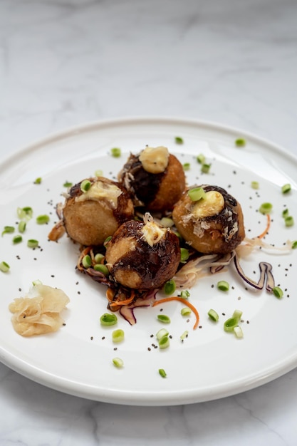 Foto un plato de takoyaki sobre una mesa de mármol.