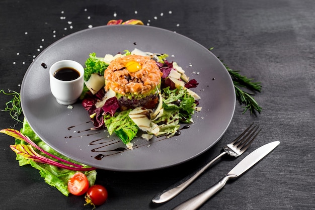 Un plato tártaro sobre fondo de madera negra