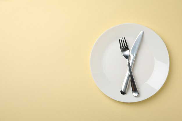 Plato con tenedor y cuchillo en color beige, vista superior