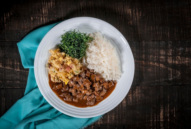 Plato típico brasileño, dados de ternera, arroz, col rizada y huevo rallado. vista superior