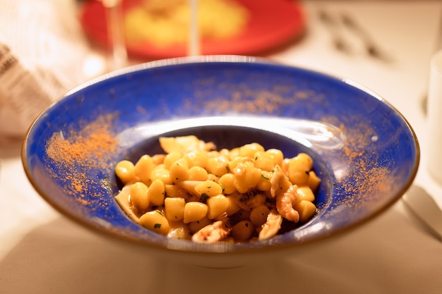 Plato típico italiano Gnocchi con mariscos. (Foto de cerca, enfoque selectivo)