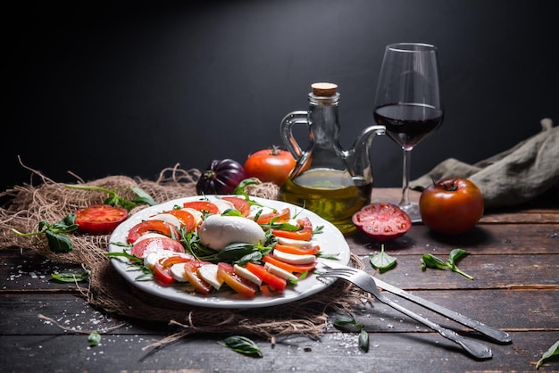 Plato típico italiano de queso mozzarella de vaca o búfala con rúcula albahaca tomate aceite de oliva