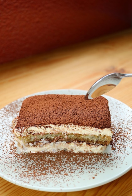 Plato de tiramisú delicioso sobre mesa de madera