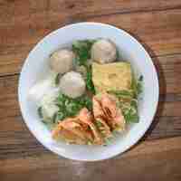 Foto un plato de tofu de albóndigas y wonton frito en la mesa de madera