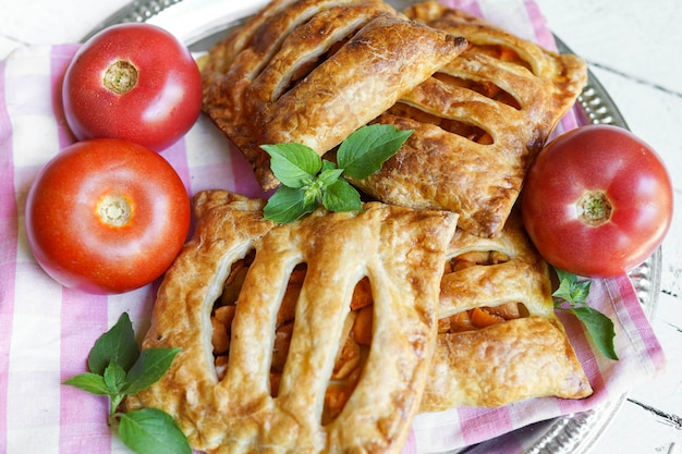 Plato con tortas caseras y hojaldre con tomates en mesa