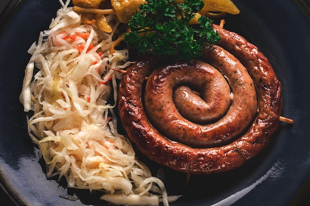 Plato tradicional alemán Salchicha en espiral frita con chucrut con salsa roja