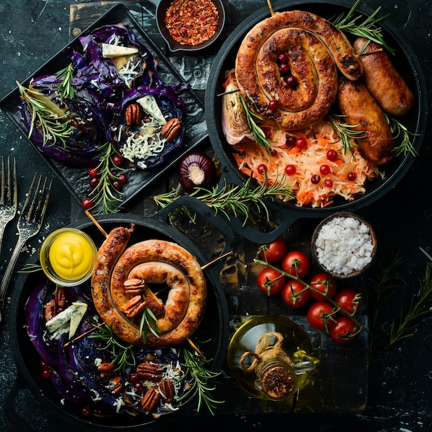 Plato tradicional alemán Salchichas a la parrilla col especias y verduras Vista superior Sobre un fondo de piedra negra