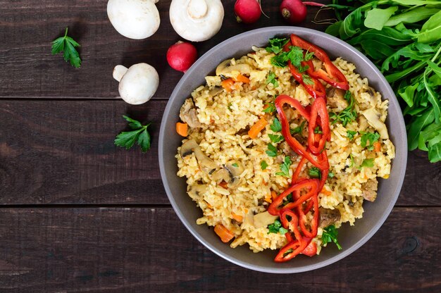 Plato tradicional asiático - pilaf con carne, champiñones y pimienta capi en un recipiente