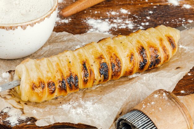 Plato tradicional georgiano khachapuri, brochetas de queso tostado en una brocheta en la masa sobre una mesa de madera.