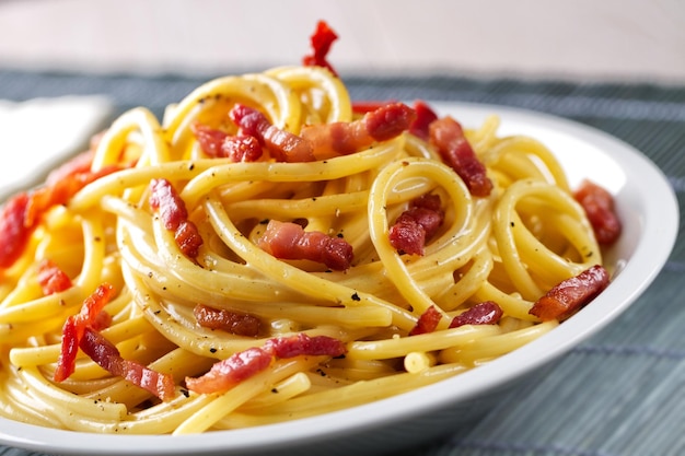 Plato tradicional italiano spaghetti carbonara con tocino en salsa de crema