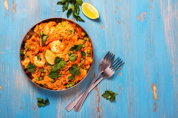 Plato tradicional de paella española con mariscos, guisantes, arroz y pollo