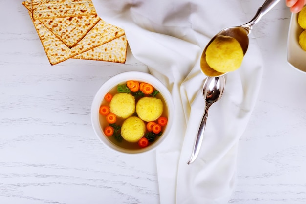 Plato tradicional de pascua judía sopa de bolas de matzá servida con símbolos judíos de matzá para la pascua