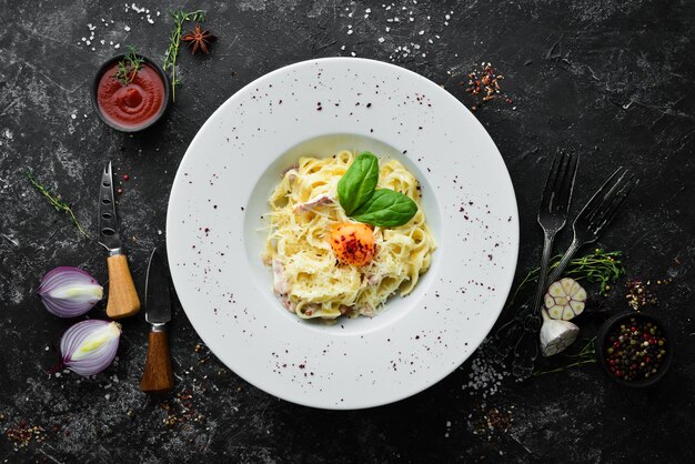 Plato tradicional de pasta italiana spaghetti carbonara con yema de queso parmesano en un plato Vista superior Espacio de copia libre