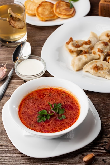 Plato tradicional ucraniano vareniki y borscht servido con chicharrones y crema agria Vista de cerca de la comida tradicional ucraniana