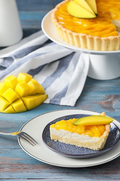 Plato con trozo de sabroso pastel de mango mesa de madera