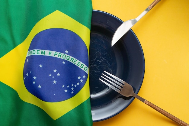 Plato vacío con bandera brasileña encima del hambre en Brasil