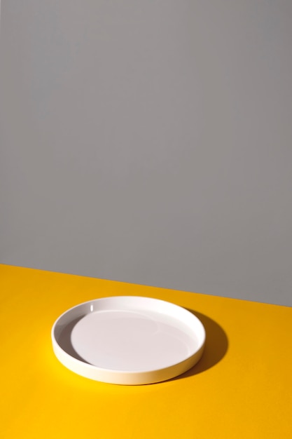 Foto plato vacío blanco sobre un fondo amarillo