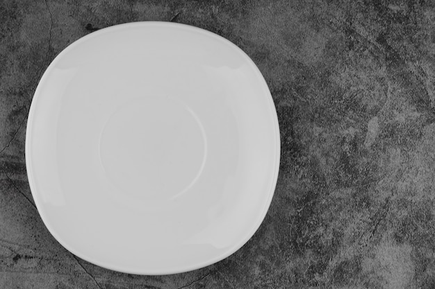 Plato vacío blanco sobre un fondo gris