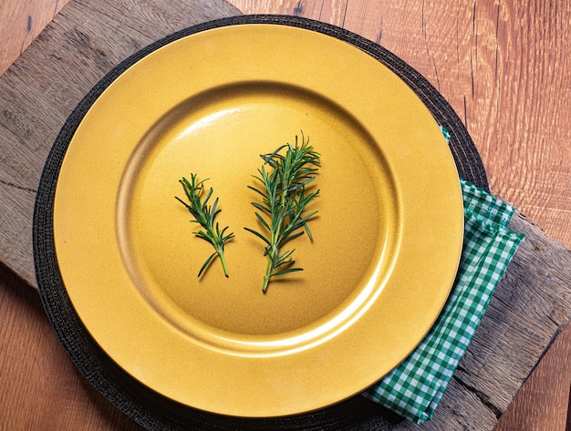 Plato vacío sobre una mesa de madera decorada con aceite de oliva tomate albahaca pimienta y rodillo