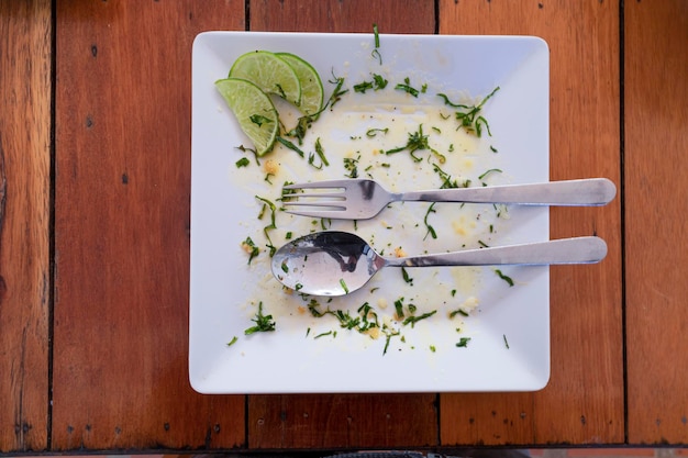 Plato vacío sucio con tenedor y cuchara, concepto de comida sabrosa, vista superior