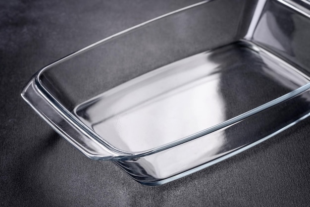 Un plato vacío de vidrio rectangular para hornear sobre un fondo de hormigón oscuro Preparación para hornear una magdalena sabrosa