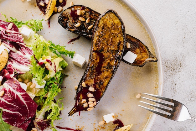 Plato vegetariano de berenjenas a la plancha con verduras, hierbas y salsa