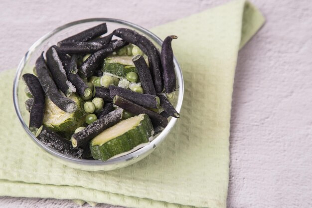 Un plato con verduras congeladas calabacín guisantes y judías verdes