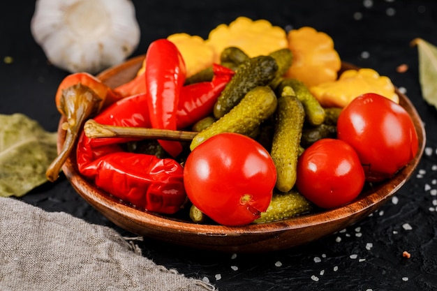 Un plato de verduras en escabeche sobre un fondo oscuro