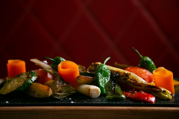 Un plato de verduras con un fondo rojo.