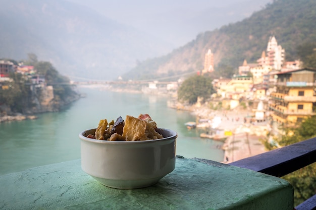 Un plato de verduras a la plancha y guisadas en el fondo del río Ganges. Rishikesh India., Ciudad de yoga India, río Gange Ganga Ram Jhoola Jula