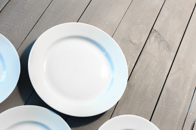 Platos blancos vacíos en mesa de madera