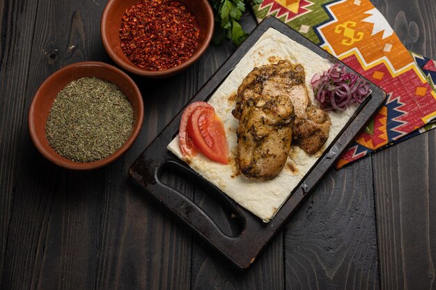 Platos de carne georgianos en una mesa de madera oscura