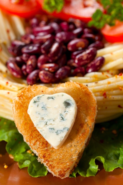 Platos para cenar decorados con pan frito y queso azul en forma de corazón.