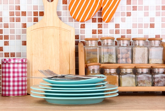 Foto platos en la cocina en la mesa sobre fondo de mosaicos