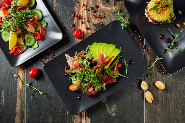 Platos con ensaladas de verduras frescas en mesa de madera