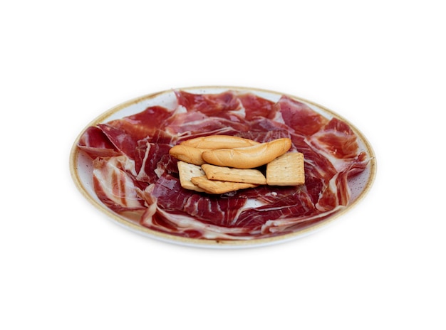 Platos de jamón ibérico y pan sobre fondo blanco.