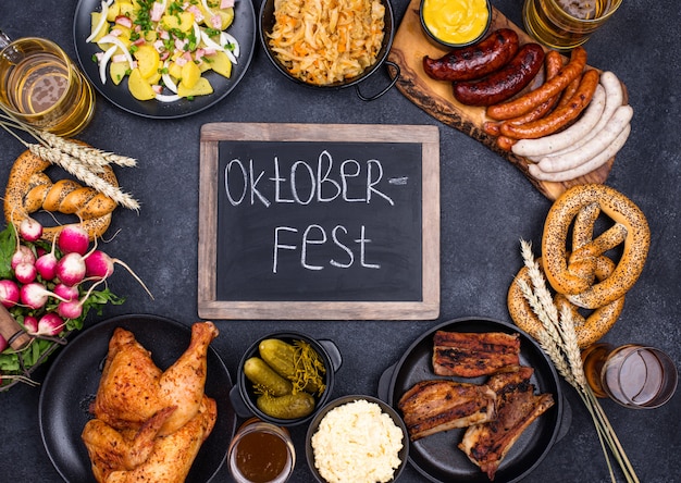 Platos de Oktoberfest: cerveza, pretzel, salchicha, repollo guisado, ensalada de papa, mitad de pollo y costillas