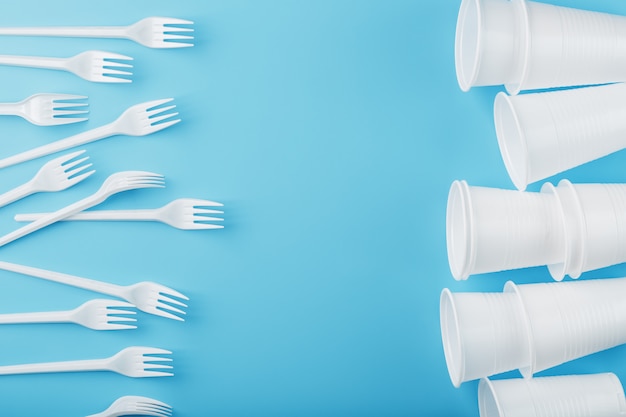 Platos de plástico blanco sobre una pared azul.