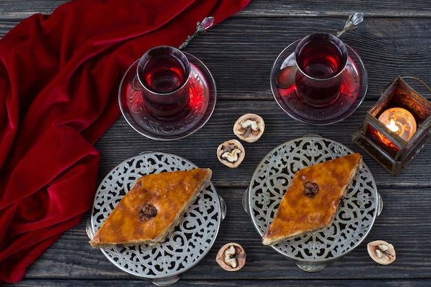 En platos de plata baklava, nueces, linterna y té. Ramadan Kareem.