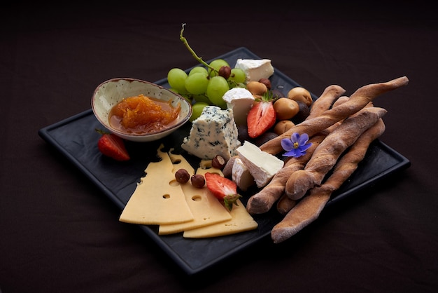 Platos de queso servidos con uvas, mermelada y nueces
