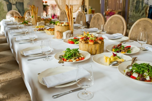 Platos y servicio en una mesa de banquete y servidos en rodajas de roble sobre una mesa