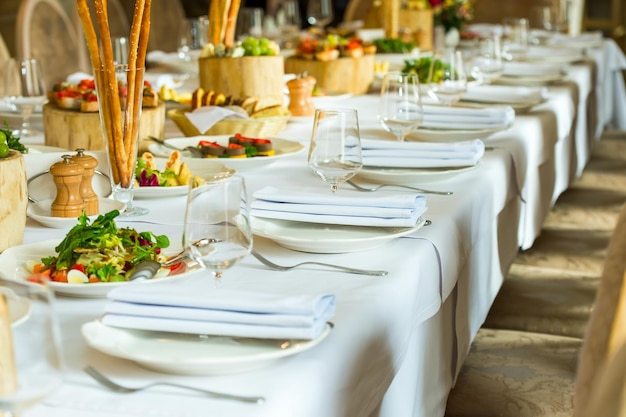 Platos y servicio en una mesa de banquete y servidos en rodajas de roble sobre una mesa