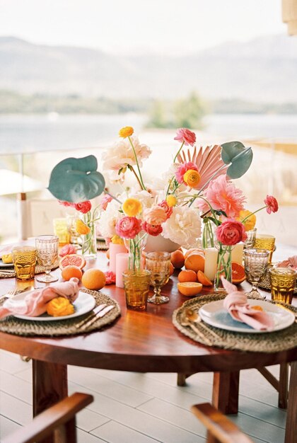 Los platos con servilletas anudadas están en esteras en una mesa con un ramo de colores