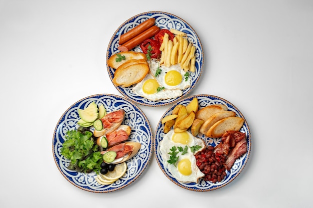 Platos tradicionales de desayuno con huevos, salchichas y varios acompañamientos dispuestos